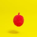 Red painted durian floating on yellow background for copy space Royalty Free Stock Photo