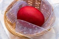 A red painted Easter egg lies in a wicker basket Royalty Free Stock Photo