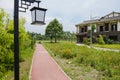 Red painted footpath before rural dwelling building in sunny sum Royalty Free Stock Photo