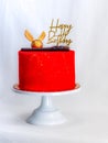 red painted frosted cake with golden topping