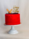 red painted frosted cake with golden topping