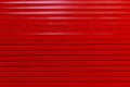 Red painted metal garage door or wall. Red garage door with black stripes