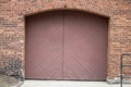 Red painted wood double door entrance of the brick structure Royalty Free Stock Photo