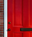 Red paneled front door detail with knob, lock and mail slot