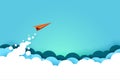 Red paper airplane flying from clouds on blue sky background.