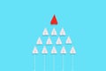 A red paper airplane leads a group of white airplanes. Blue background. Flat lay. The concept of leadership and success