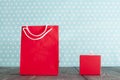 Red paper bag and gift box on wooden table Royalty Free Stock Photo