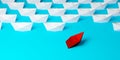 Red paper boat driving away from uniform group of white paper ships on blue background, difference or business leadership concept Royalty Free Stock Photo