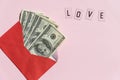 Red paper envelope with money dollars bills. pink background with Valentine gift, letter, love word. Top view, mock