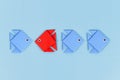 Red paper fish swimming swimming against the current in opposite direction of blue fish Royalty Free Stock Photo