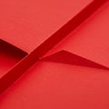 Red paper folded to create sharp, intersecting lines and geometric shapes. The textu Royalty Free Stock Photo