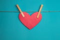 Red paper heart attached to a rope with wooden pins