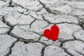 A red paper heart on dry cracked soil Royalty Free Stock Photo