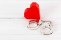 Red Paper Heart with Handcuffs on white wood background. Freedom of Love and Law Concept with white wood background Royalty Free Stock Photo