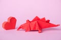 Paper heart near origami dinosaur on