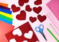 Red paper hearts, color papers, scissors, ruler, pen and pencil for Valentine`s day card crafts on pink background. Top view. Royalty Free Stock Photo