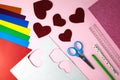 Red paper hearts, color papers, scissors, ruler, pen and pencil for Valentine`s day card crafts on pink background. Top view. Royalty Free Stock Photo