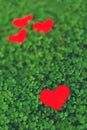 Red paper hearts in green clover