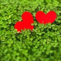 Red paper hearts in green clover