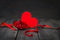 Red paper hearts rose and fork with ribbon. Dark wooden background. Copy space. Valentine`s Day.