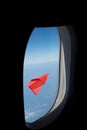 Red paper plane in the blue sky .View from Window airplane. Royalty Free Stock Photo