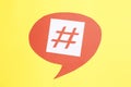 Red paper speech bubble with hashtag symbol on yellow background, top view Royalty Free Stock Photo