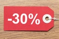Red paper tag labeled with -30% word isolated on wooden background Royalty Free Stock Photo