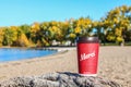 Red Paper Tim Hortons cup of coffee with Merci word on natural morning background