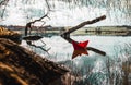 Red paperboat in a beautiful lake