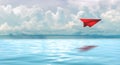 Red paperplane in the beautiful seascape with cloud on a sunny day Royalty Free Stock Photo