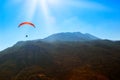 Red parachute in the sky above the mountains. Royalty Free Stock Photo