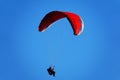 Red paraglider in a blue sky