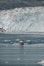 Red Passenger cruise ship sailing through the icy waters of Qasigiannguit, Greenland with Eqip Sermia Eqi Glacier in Royalty Free Stock Photo