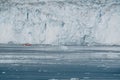 Red Passenger cruise ship sailing through the icy waters of Qasigiannguit, Greenland with Eqip Sermia Eqi Glacier in Royalty Free Stock Photo