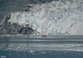 Red Passenger cruise ship sailing through the icy waters of Qasigiannguit, Greenland with Eqip Sermia Eqi Glacier in