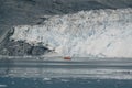 Red Passenger cruise ship sailing through the icy waters of Qasigiannguit, Greenland with Eqip Sermia Eqi Glacier in Royalty Free Stock Photo