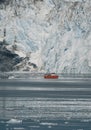 Red Passenger cruise ship sailing through the icy waters of Qasigiannguit, Greenland with Eqip Sermia Eqi Glacier in Royalty Free Stock Photo