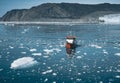 Red Passenger cruise ship sailing through the icy waters of Qasigiannguit, Greenland with Eqip Sermia Eqi Glacier in Royalty Free Stock Photo