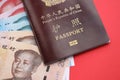 Red passport of People Republic of China and chinese yuan money bills. PRC chinese passport Royalty Free Stock Photo