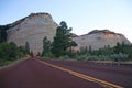 The red paved road towards the white Checkerboard Mesa during a summer sunset in Zion National Park Royalty Free Stock Photo