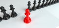 Red pawn of chess, standing out from the crowd of blacks - leadership concept