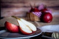 A red pear cut in half and other juicy red battler pears in a basket. Organic and natural products. Healthy food