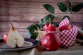 A red pear cut in half and other juicy red battler pears in a basket. Organic and natural products. Normal View