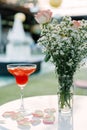 Red pear juice in a glass placed on a table decorated with flowers and daisies. Royalty Free Stock Photo