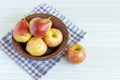 Red pears and apple in brown plate on white wooden table Royalty Free Stock Photo