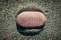 Pebble stone alone on sand with word Isolation carved on it in a conceptual image Royalty Free Stock Photo