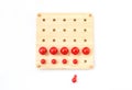 Red pegs board, wood beads on white background