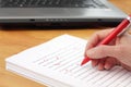 Red Pen Proofreading a Manuscript by Laptop Royalty Free Stock Photo