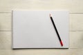 Red pencil on blank white album paper. Top view. school and office supplies. Copy space