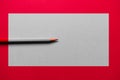Red pencil over a red background, with a grey rectangle in the middle Royalty Free Stock Photo